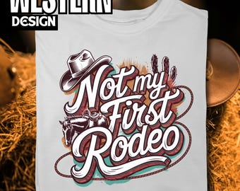 May include: White t-shirt with a graphic design of a cowboy hat, cactus, and the text "Not my first rodeo".