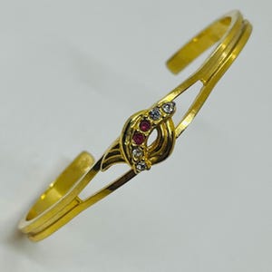 Beautiful Gold Tone Imitation Diamond + Simulated Red Ruby Torque Bangle. Gorgeous Simulated Diamond Imitation Ruby Gold Tone Torque Bangle