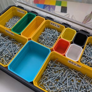 May include: A clear-lidded organizer with multiple compartments filled with screws. The compartments are various colors, including yellow, green, blue, red, and white. The sizes of the screws are labeled as 3.5 x 12, 4.0 x 16, 4.0 x 30, and 4.0 x 40.