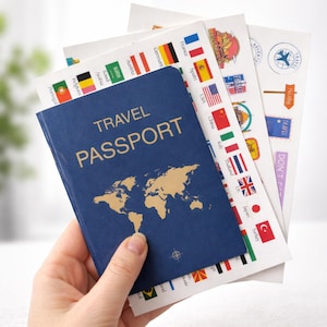 May include: A blue travel passport with gold lettering and a world map design is held with several sheets of stickers featuring flags and travel-themed graphics. The passport reads "TRAVEL PASSPORT".