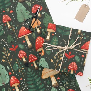 Peut inclure: Papier cadeau vert fonc&eacute; avec un motif r&eacute;p&eacute;t&eacute; de champignons rouges et beiges, de feuilles vertes et de points blancs. Une bo&icirc;te cadeau emball&eacute;e avec le m&ecirc;me motif est attach&eacute;e avec de la ficelle. Des ciseaux et une &eacute;tiquette vierge sont &eacute;galement pr&eacute;sents.