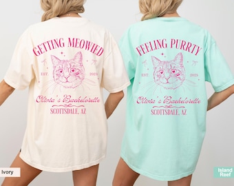 May include: Two white and light blue t-shirts with a cat illustration and the text "Getting Meowied" and "Feeling Purrty". The text also includes "Olivia's Bachelorette, Scottsdale, AZ" and "Est. 2025".