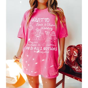 May include: Pink t-shirt with a white graphic design that says "Went to Noah & Olivia Wedding May 2025 Charleston, SC and all I got was this lousy shirt".