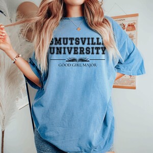 May include: An oversized light blue t-shirt with black text that reads "Mutsville University" and "Good Girl Major".