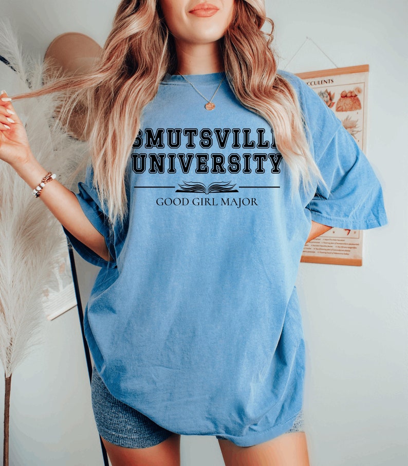 May include: An oversized light blue t-shirt with black text that reads "Mutsville University" and "Good Girl Major".