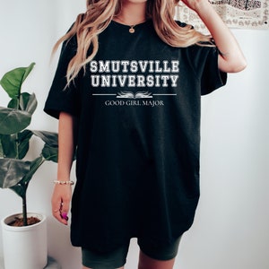 May include: Black oversized t-shirt with white text that reads "Smutsville University Good Girl Major".