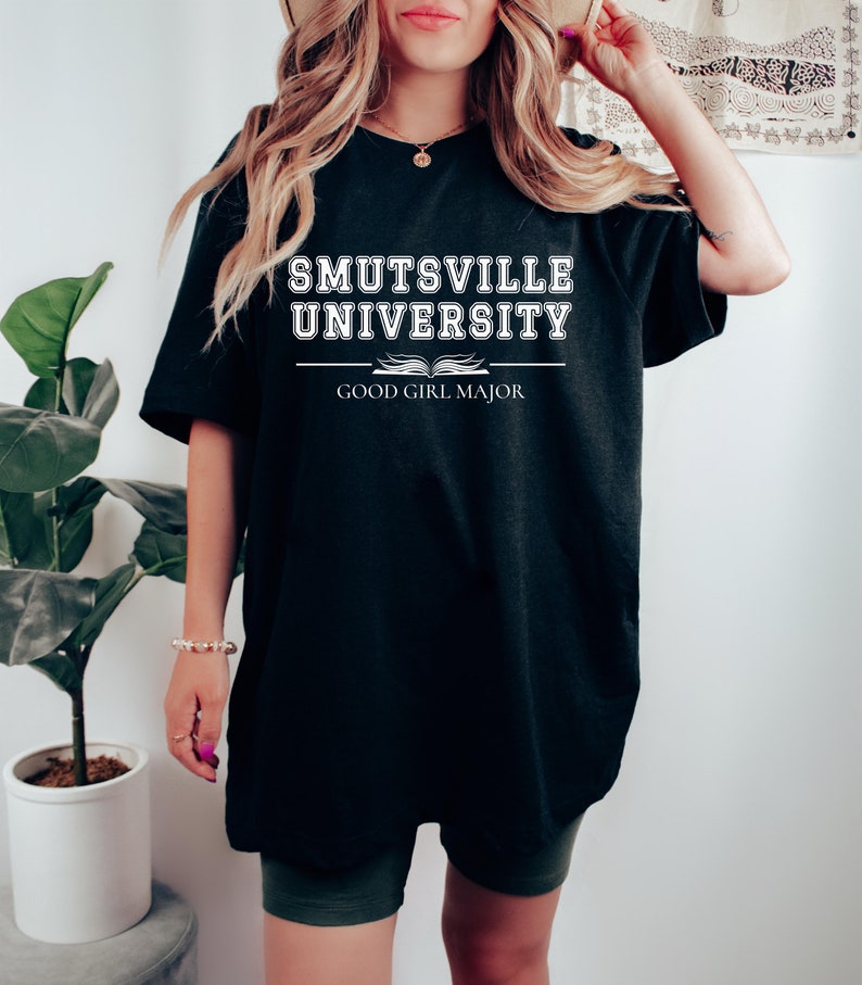 May include: Black oversized t-shirt with white text that reads "Smutsville University Good Girl Major".