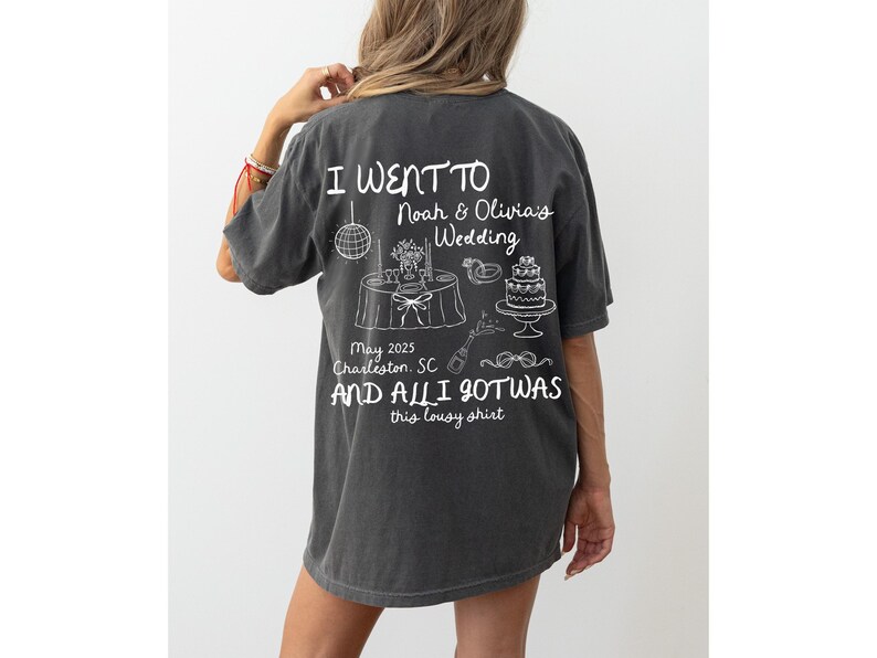 May include: A dark gray t-shirt with white text that reads "I went to Noah & Olivia's Wedding May 2025 Charleston, SC and all I got was this lousy shirt".