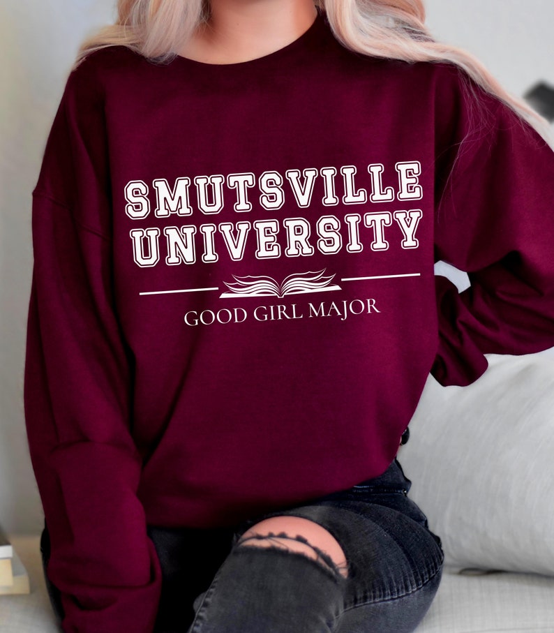 May include: Burgundy sweatshirt with white text that reads "Smutsville University" and "Good Girl Major" with an open book graphic.