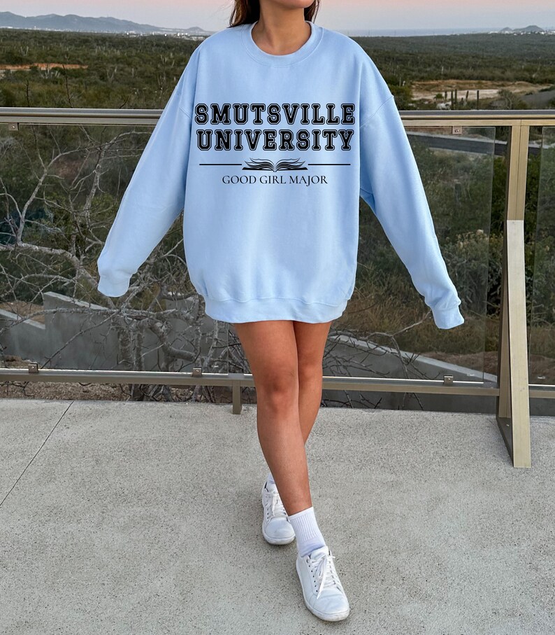 May include: A light blue sweatshirt with the text "Smutsville University" and "Good Girl Major" printed on the front.