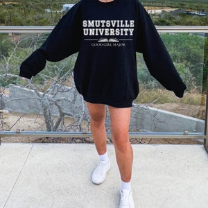 May include: Black sweatshirt with white text that reads "Smutsville University Good Girl Major".