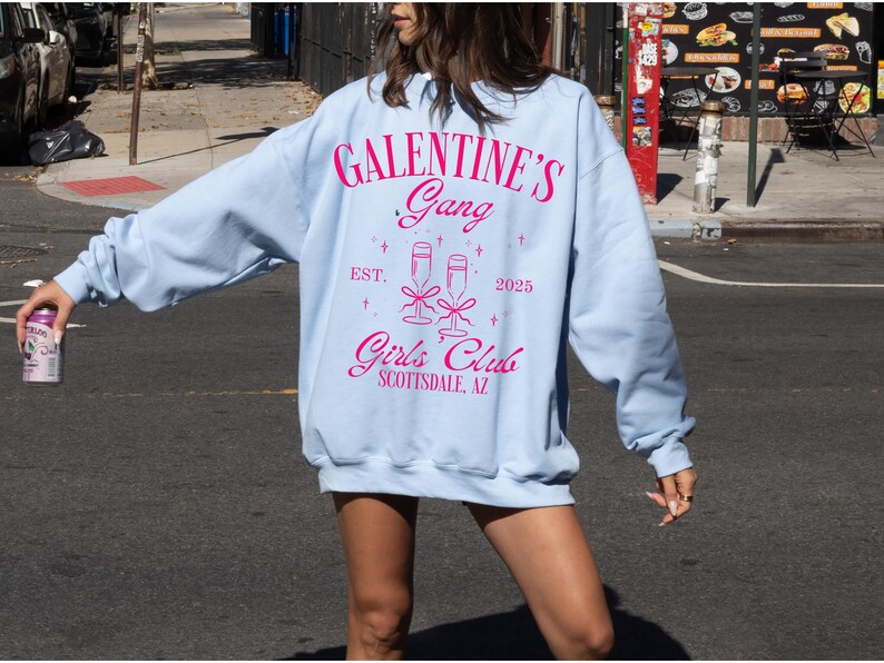 May include: Light blue sweatshirt with a pink graphic that says "Galentine's Gang Est. 2025 Girls Club Scottsdale, AZ"