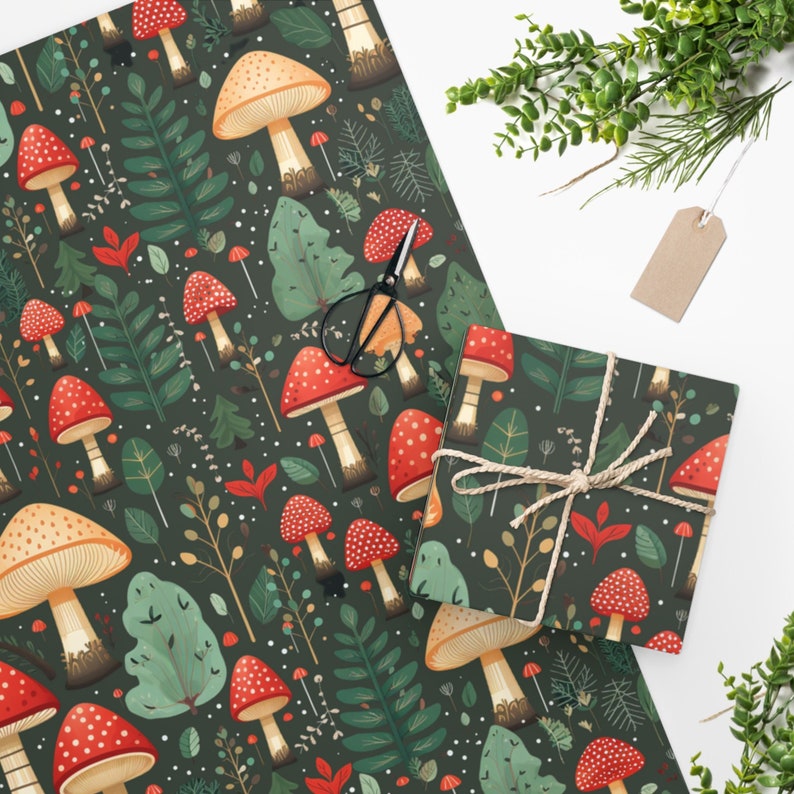 Peut inclure: Papier cadeau vert fonc&eacute; avec un motif r&eacute;p&eacute;t&eacute; de champignons rouges et beiges, de feuilles vertes et de points blancs. Une bo&icirc;te cadeau emball&eacute;e avec le m&ecirc;me motif est attach&eacute;e avec de la ficelle. Des ciseaux et une &eacute;tiquette vierge sont &eacute;galement pr&eacute;sents.