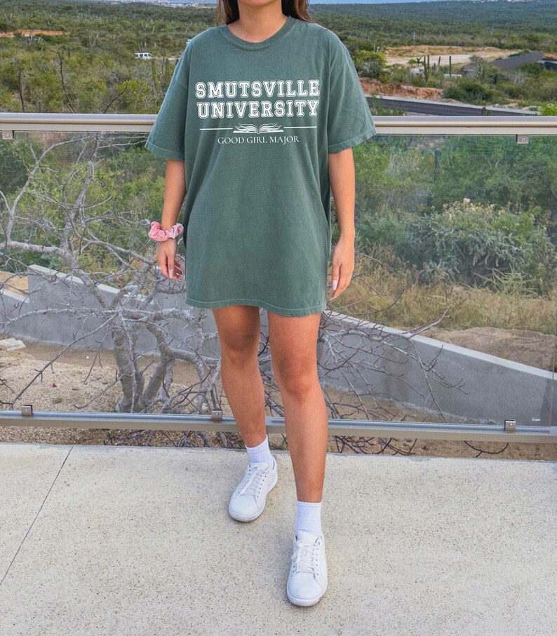 May include: A green t-shirt with the text "Smutsville University" and "Good Girl Major" printed on the front.