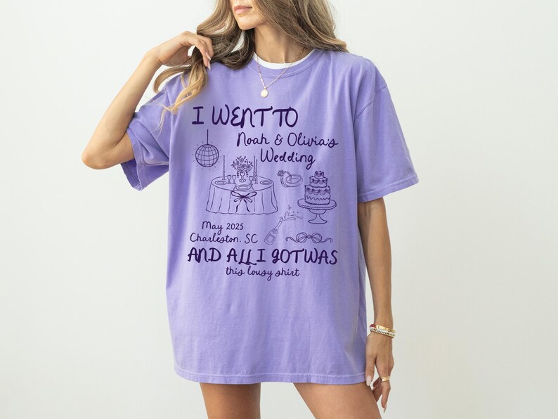 May include: Purple t-shirt with a graphic design that says "I went to Noah & Olivia's Wedding May 2025 Charleston, SC and all I got was this lousy shirt".