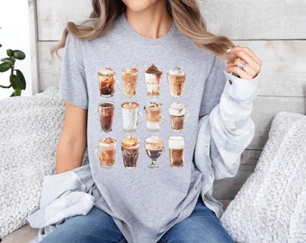 Puede incluir: Una camiseta gris con un gráfico de 16 bebidas de café diferentes. Las bebidas están todas en vasos de vidrio y tienen diferentes ingredientes, como crema batida, chocolate y caramelo.