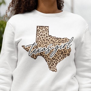 May include: White sweatshirt with a leopard print outline of the state of Texas and the text "Texas girl" in black script.