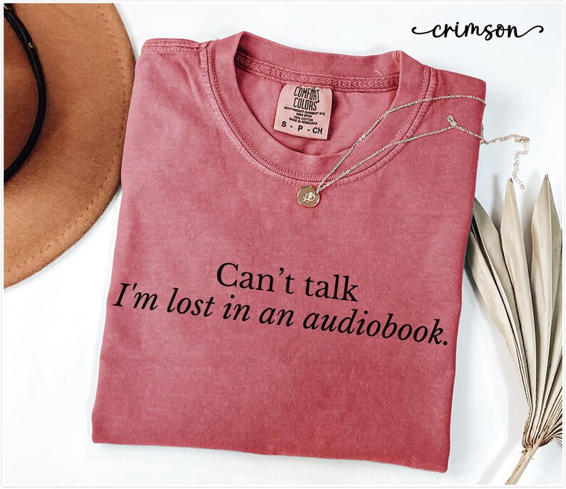 May include: Crimson red t-shirt with the text "Can't talk I'm lost in an audiobook."
