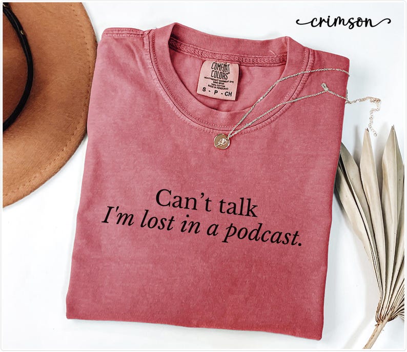 May include: Crimson red t-shirt with the text "Can't talk I'm lost in a podcast."