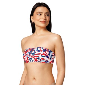May include: A strapless bandeau top with a patriotic design. The top features a white background with a pattern of red and blue stars and streaks. The garment is made of a soft, comfortable material.