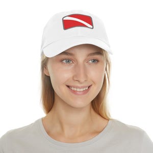May include: White baseball cap with a red and gray scuba diving flag patch on the front.