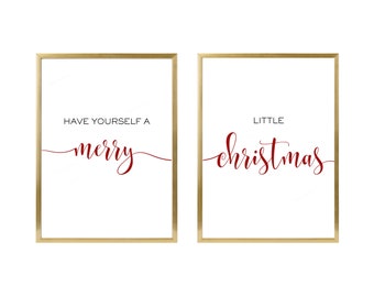 May include: Two gold framed prints with white backgrounds and red cursive text. The left print says "Have yourself a merry" and the right print says "Little Christmas".