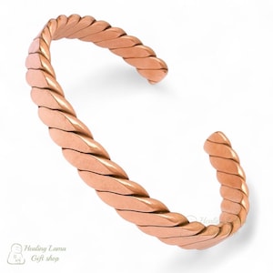 May include: A copper-colored cuff bracelet with a braided design. The open-ended bracelet has a textured, twisted pattern. The bracelet is made of a solid metal and is displayed on a white background. The bracelet is a piece of jewelry.