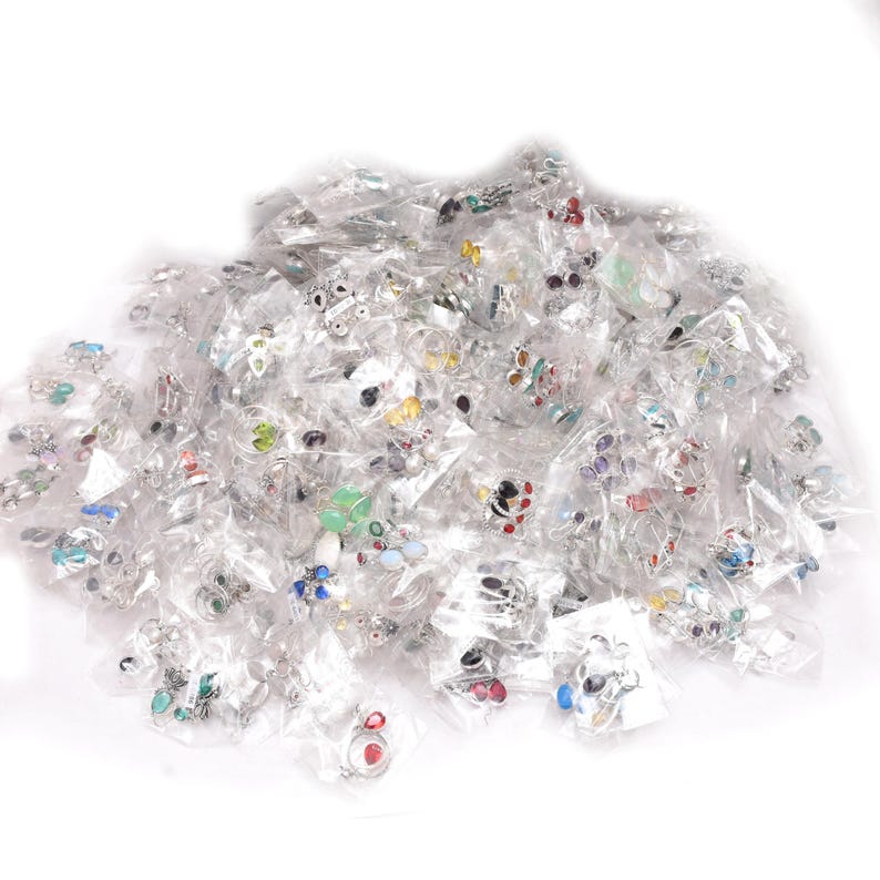 Puede incluir: Una colecci&oacute;n de anillos variados, cada uno empaquetado individualmente en pl&aacute;stico transparente. Los anillos presentan diversos dise&ntilde;os, incluyendo piedras preciosas coloridas y intrincados trabajos en metal. La imagen muestra una variedad de estilos y colores.