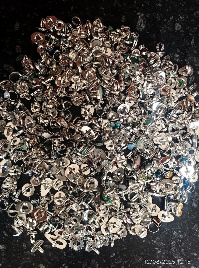 Puede incluir: Una gran colecci&oacute;n de anillos de plata con diversos dise&ntilde;os y piedras preciosas. Los anillos est&aacute;n dispersos, mostrando una variedad de formas, tama&ntilde;os y adornos, incluyendo turquesas, &oacute;palos y otras piedras de colores. La imagen es tomada desde arriba.
