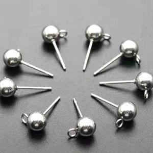 Op de afbeelding: Tien zilveren oorbelpennen met ronde bolvormige toppen. De pennen zijn ongeveer 2,5 cm lang.