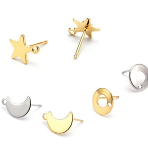 May include: Five gold and silver earring findings with different shapes, including a star, a crescent moon, and a circle. The findings are all made of metal and have a shiny finish.