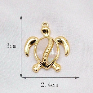 May include: Gold-tone turtle pendant charm with a white shell design. The pendant measures approximately 2.4 inches in length and 3 inches in width.
