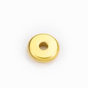 May include: A gold-coloured, circular cabinet knob with a central hole. The knob has a smooth, rounded edge and a polished finish. The hardware is designed for use on drawers, cabinets, or other furniture.