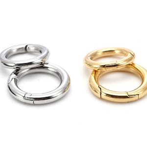 以下が含まれることがあります： 銀と金の金属製のキーリングのセットが2つ。各セットには、スイベルクラスプで接続された2つのリングがあります。