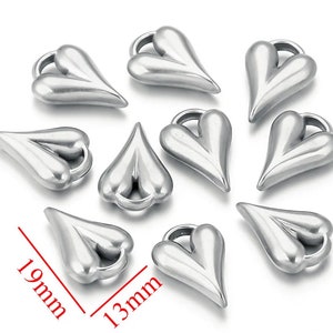 May include: Ten silver heart-shaped charms with a loop at the top. The charms are 19 mm long and 13 mm wide.