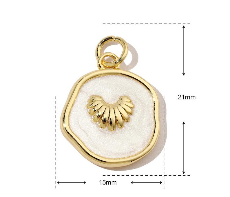 K&ouml;nnte beinhalten: Goldfarbener Anh&auml;nger mit einem wei&szlig;en Emaille-Zentrum, das ein stilisiertes Herzdesign zeigt. Der Anh&auml;nger ist 15 mm breit und 21 mm hoch.