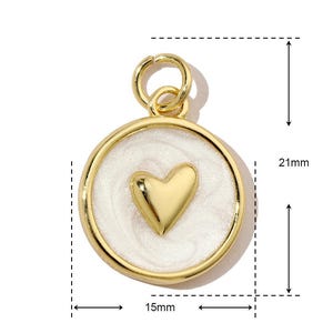 K&ouml;nnte beinhalten: Goldfarbener Anh&auml;nger mit einem wei&szlig;en Emaille-Herz-Design. Der Anh&auml;nger ist 15 mm im Durchmesser und 21 mm hoch.