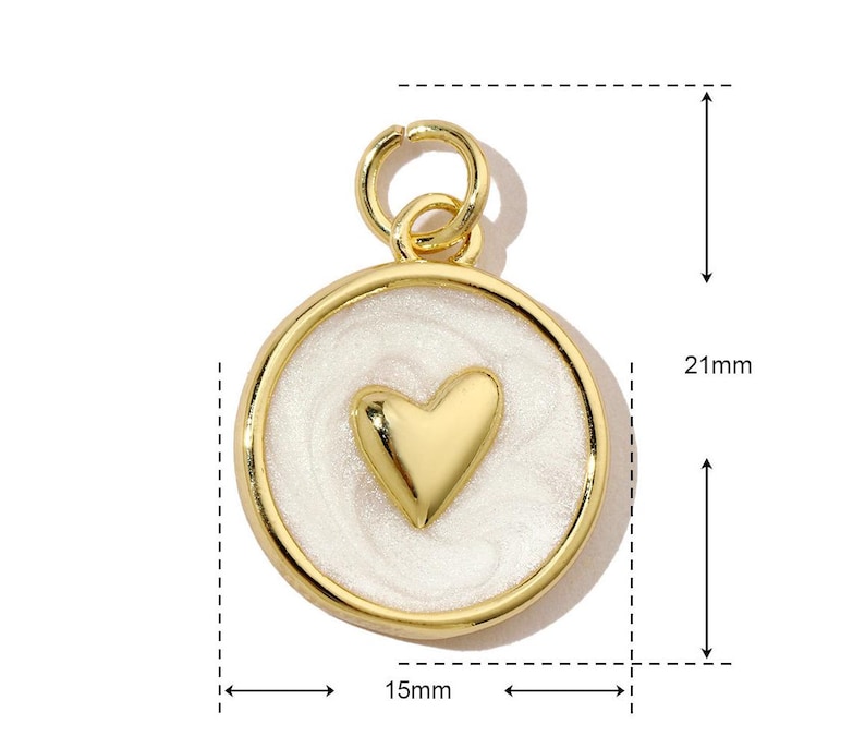 K&ouml;nnte beinhalten: Goldfarbener Anh&auml;nger mit einem wei&szlig;en Emaille-Herz-Design. Der Anh&auml;nger ist 15 mm im Durchmesser und 21 mm hoch.