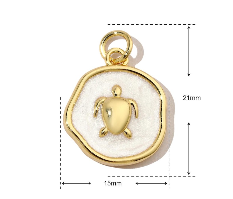 K&ouml;nnte beinhalten: Goldfarbener Anh&auml;nger mit einem wei&szlig;en Emaille-Schildkr&ouml;ten-Design. Der Anh&auml;nger ist 15 mm breit und 21 mm hoch.