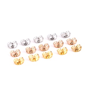 May include: A set of 12 earring backs in three different colours: silver, gold, and rose gold. The backs are shaped like a heart and have a small opening in the centre.