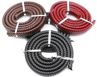 Può includere: Tre cordoni in pelle di diversi colori: marrone, rosso e nero. I cordoni sono intrecciati e hanno una superficie testurizzata.