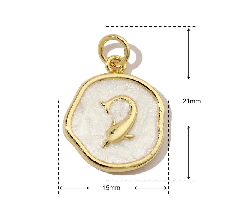 K&ouml;nnte beinhalten: Goldfarbener Anh&auml;nger mit wei&szlig;er Emaille-Oberfl&auml;che. Der Anh&auml;nger zeigt ein stilisiertes Delfin-Design und die Zahl "2" in der Mitte. Der Anh&auml;nger ist 15 mm breit und 21 mm hoch.