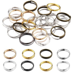 Pu&ograve; includere: Assortimento di portachiavi in oro, argento e bronzo. I portachiavi sono di diverse dimensioni e sono disposti in un motivo casuale.