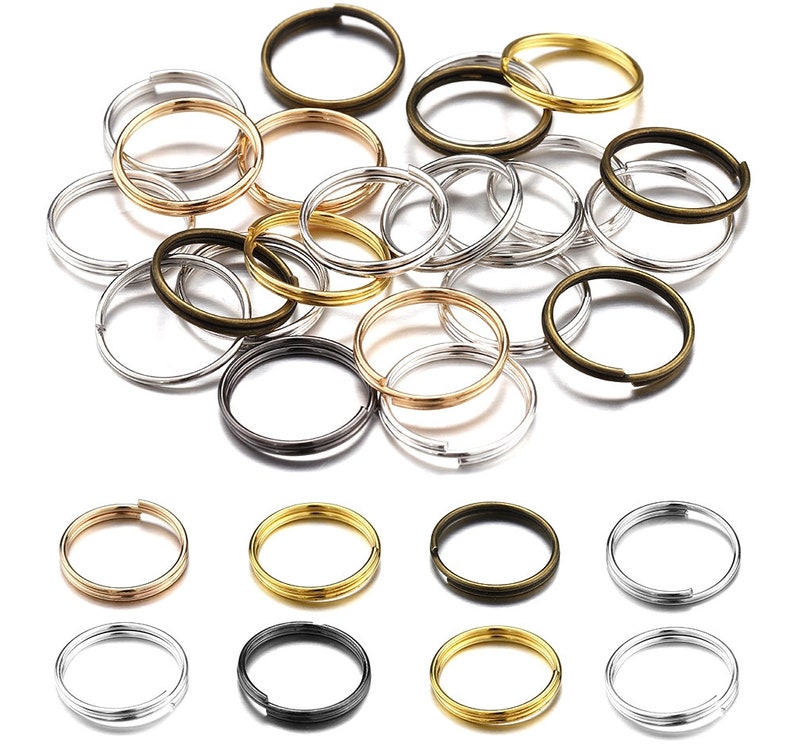 Pu&ograve; includere: Assortimento di portachiavi in oro, argento e bronzo. I portachiavi sono di diverse dimensioni e sono disposti in un motivo casuale.