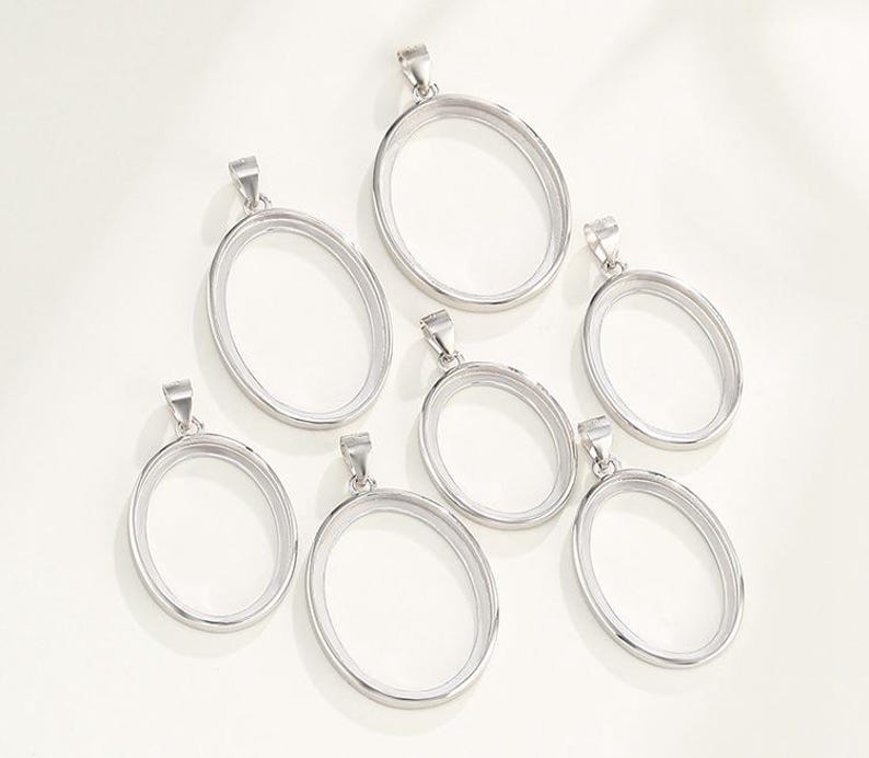 Puede incluir: Conjunto de siete marcos ovalados de plata para colgantes de diferentes tama&ntilde;os. Los marcos son de metal y tienen un acabado liso y pulido.