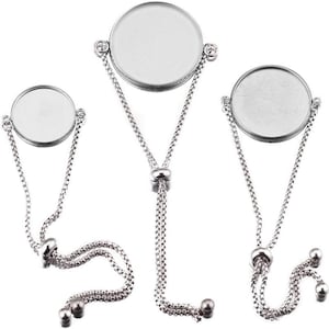 May include: Three silver-toned adjustable bracelets with round, blank bezels. Each bracelet features a delicate chain and a sliding knot for adjustment. The bezels are ready for customization, perfect for DIY jewelry projects.