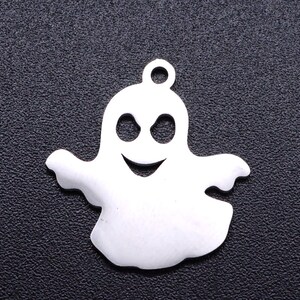 May include: A white metal ghost charm with a smiling face and two eyes. The charm is ideal for adding a spooky touch to jewellery or crafts.