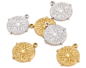 May include: Six gold and silver sun charm pendants with a textured design. The charms have a loop at the top for attaching to a necklace or bracelet.