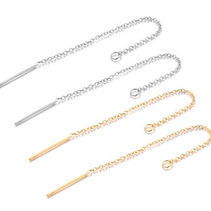 Può includere: Due paia di orecchini pendenti con un'asta sottile e dritta e una catena delicata. Un paio è argentato e l'altro è dorato.