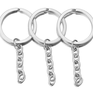 May include: Three silver keychains with attached chains. Each keychain is a simple circle.